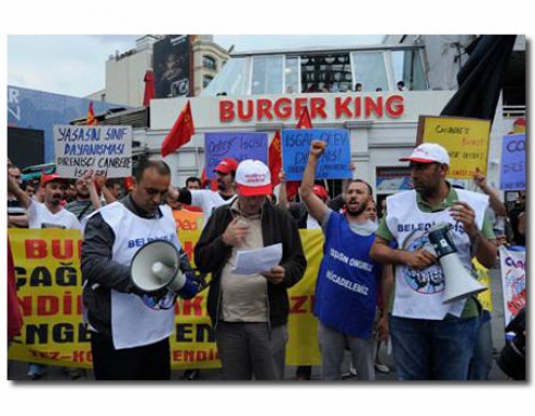 Trabalhadores demitidos da rede Burguer King por se sindicalizarem, se organizam em frente a uma loja da rede em frente à Taksim Square